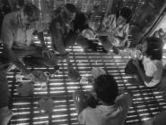 Missionary Boe Stanley (left) enjoys a meal with some friends as sunlight shines through a split-bamboo floor in the rural Philippines. Rutledge was a master of capturing light and darkness in his photographs.