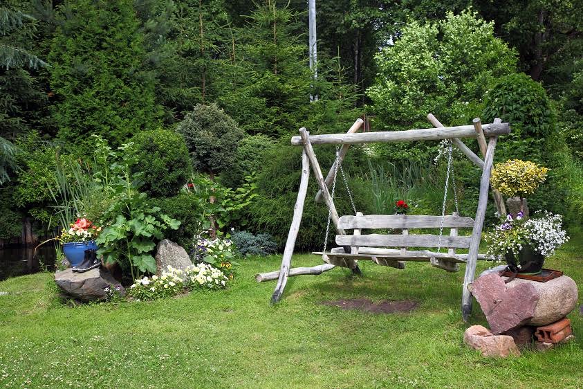 Wood swing in the green garden